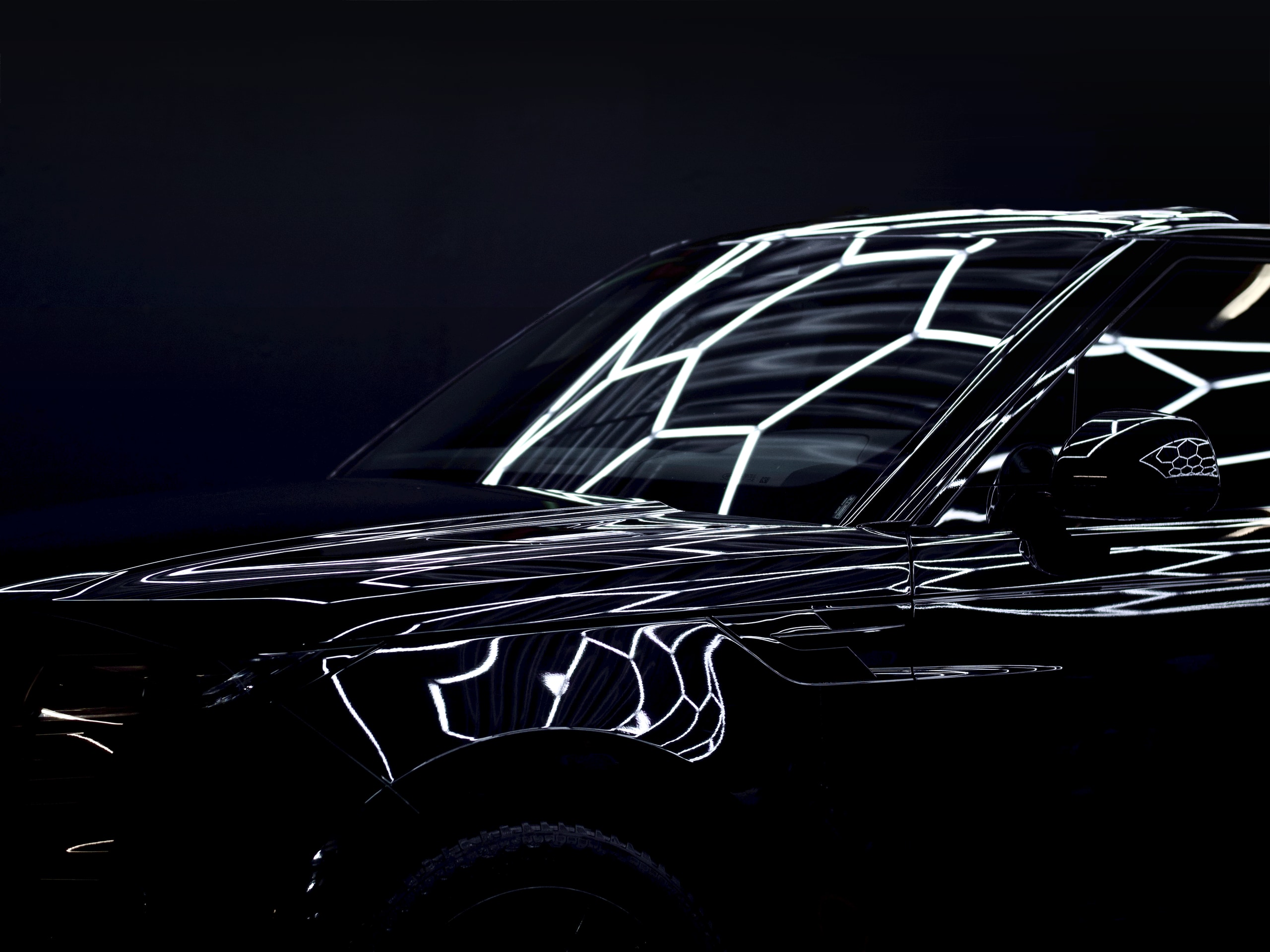 Gloss black vehicle in the Black Diamond studio with hexagon light reflections